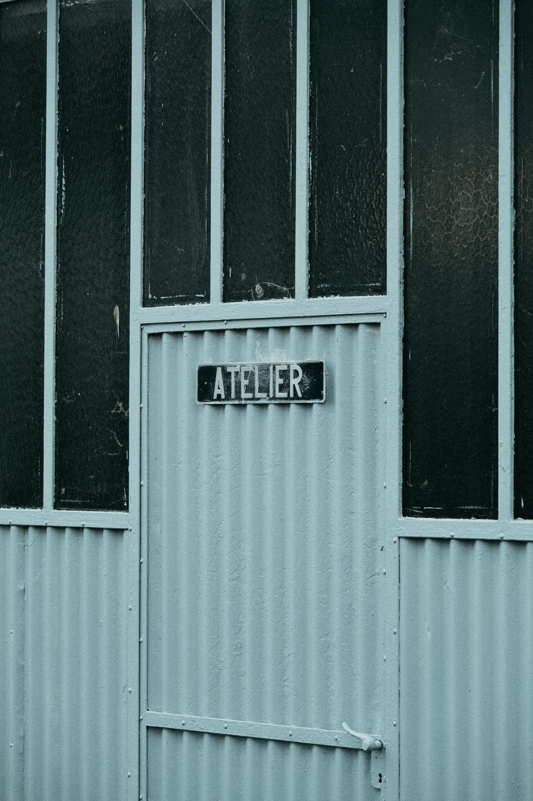Close-up texture from the atelier — green panels and signage.