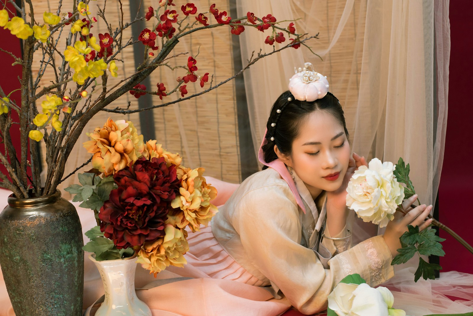 a woman sitting on a table with flowers in vases